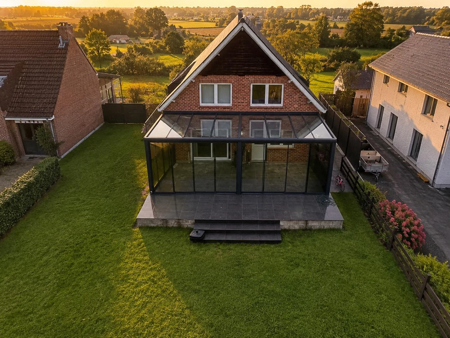 Haus mit einem Glasanbau über die gesamte Rückfront, von oben bei Sonnenuntergang, montiert von SAVA Glass