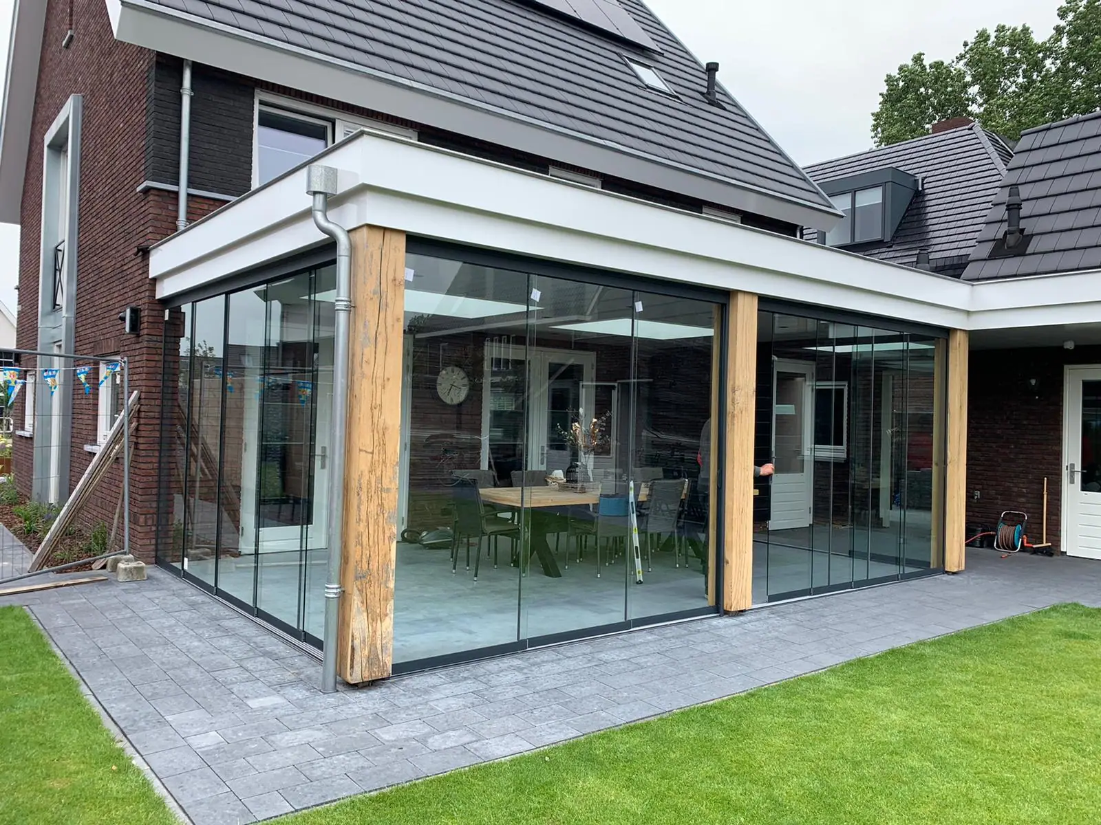 Gartenzimmer am Haus mit Eichenstützen und Glasschiebewänden über zwei Seiten